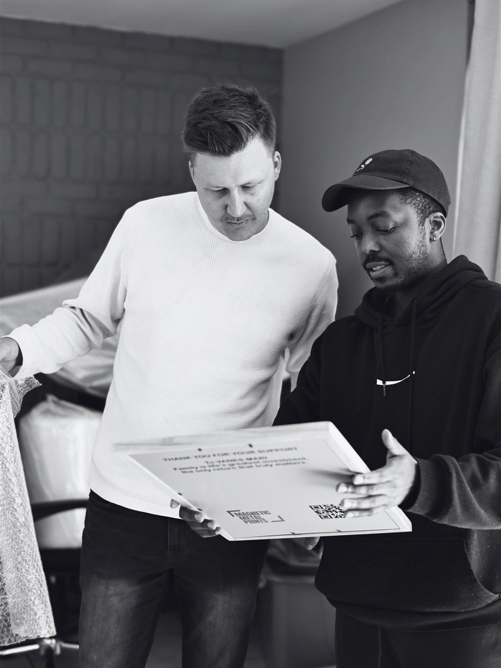 Deon Dee and Potego Matseke, founders of Magnetic Metal Prints, reviewing a finished print